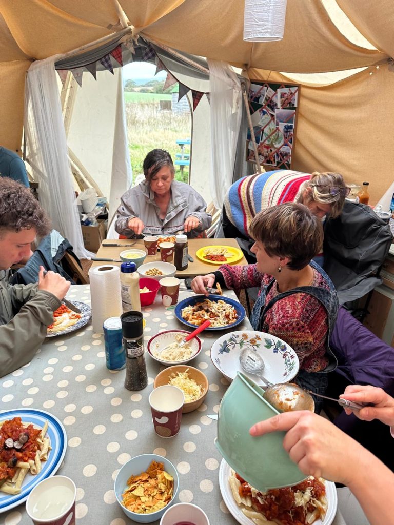 enjoying a meal together sat around a long table